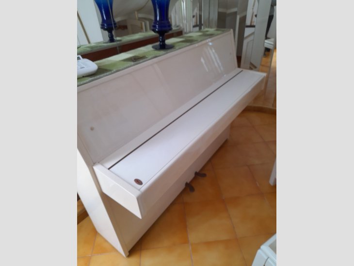 Es ven piano vertical de color blanc, en perfecte estat 2