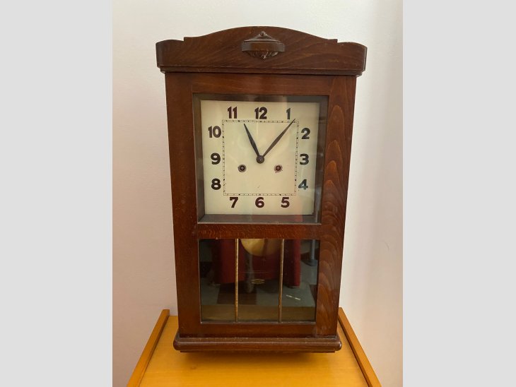 Reloj de pared con caja de madera clásica y péndulo oscilante